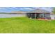 Lush backyard with green lawn, privacy fence, and screened patio area at 10915 Kirkwall Port Dr, Wimauma, FL 33598