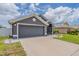 Charming single-story home featuring a well-manicured lawn and a two-car garage with inviting curb appeal at 10915 Kirkwall Port Dr, Wimauma, FL 33598