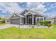 Charming single-story home featuring a well-manicured lawn and a two-car garage with inviting curb appeal at 10915 Kirkwall Port Dr, Wimauma, FL 33598