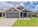 Charming single-story home featuring a well-manicured lawn and a two-car garage with inviting curb appeal at 10915 Kirkwall Port Dr, Wimauma, FL 33598