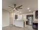 Open kitchen with stainless steel appliances, peninsula, and wood-look tile flooring at 10915 Kirkwall Port Dr, Wimauma, FL 33598