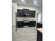 Modern kitchen features stainless steel appliances and dark cabinets against beautiful tile floors at 10915 Kirkwall Port Dr, Wimauma, FL 33598