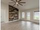 Bright living room with wood-look tile flooring, a ceiling fan, and a decorative wood accent wall at 10915 Kirkwall Port Dr, Wimauma, FL 33598