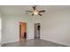 Main bedroom with wood-look tile floors, ceiling fan and en-suite bathroom at 10915 Kirkwall Port Dr, Wimauma, FL 33598