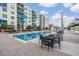 Resort-style swimming pool with lounge seating and umbrellas outside a modern condo building on a sunny day at 1120 E Kennedy Blvd # 912, Tampa, FL 33602