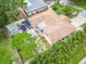 An aerial view shows the backyard with patio furniture, gazebo, palm trees, and a shed at 113 Maplewood Ave, Clearwater, FL 33765