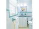 Clean bathroom featuring white tile, blue accents, and a modern vanity and toilet at 113 Maplewood Ave, Clearwater, FL 33765
