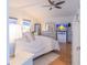 Bright bedroom boasts ceiling fan, white paint, bedside tables and dressers with a wooden floor at 113 Maplewood Ave, Clearwater, FL 33765