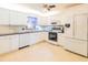 Bright kitchen featuring white cabinets, stainless steel appliances, and a modern ceiling fan at 113 Maplewood Ave, Clearwater, FL 33765