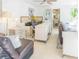 Open-concept living space with leather sofas, tiled floor, and adjoining kitchen with sink at 113 Maplewood Ave, Clearwater, FL 33765