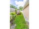 Side yard featuring a well-maintained lawn, wooden fence, and a pathway leading to a gate, offering a private outdoor space at 113 Maplewood Ave, Clearwater, FL 33765