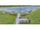 Dock overlooking a large pond surrounded by green grass and wetlands at 11315 Chilly Water Ct, Riverview, FL 33579