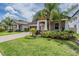 Well-maintained front yard with tropical landscaping and a two-car garage at 11315 Chilly Water Ct, Riverview, FL 33579