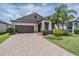 Charming single-Gathering home with a well-manicured lawn, beautiful landscaping, and a brick-paved driveway at 11315 Chilly Water Ct, Riverview, FL 33579