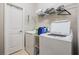 Bright laundry room with a washing machine, dryer, storage shelving, and tile floor at 11315 Chilly Water Ct, Riverview, FL 33579