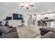 Open-concept living area with a large TV, exercise bike, sofa, and a view of the kitchen at 11315 Chilly Water Ct, Riverview, FL 33579