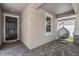 Inviting front porch with a hanging chair and brick flooring at 11315 Chilly Water Ct, Riverview, FL 33579