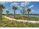 A lush backyard with manicured landscaping offers tranquil lake views and serene paved walking path at 11619 Cambium Crown Dr, Riverview, FL 33569