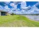 Backyard view showcasing a well-maintained lawn leading to a tranquil lake, ideal for relaxation at 11619 Cambium Crown Dr, Riverview, FL 33569