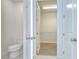 Bright bathroom with a toilet and a walk-in closet space with wood floor and white shelves at 11619 Cambium Crown Dr, Riverview, FL 33569