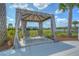 A shaded poolside cabana with lounge chairs offers tranquil views of the lake and surrounding greenery at 11619 Cambium Crown Dr, Riverview, FL 33569