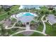 Aerial view of a community pool with playground, cabanas, and manicured landscaping near a scenic lake at 11619 Cambium Crown Dr, Riverview, FL 33569