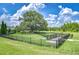 Large, fenced dog park with ample green space, trees, and separate areas for large and small dogs at 11619 Cambium Crown Dr, Riverview, FL 33569