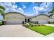 Charming single-story home featuring a well-manicured lawn and a triple car garage at 11619 Cambium Crown Dr, Riverview, FL 33569
