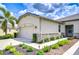 Well-maintained garage featuring stone accents and lush landscaping at 11619 Cambium Crown Dr, Riverview, FL 33569