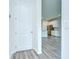 Hallway looking into the kitchen and featuring white door and gray floors at 11619 Cambium Crown Dr, Riverview, FL 33569