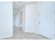 Hallway with a wood floor leading to an interior door and a white front door at 11619 Cambium Crown Dr, Riverview, FL 33569