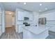 Modern kitchen features white cabinets, stainless appliances, and a center island at 11619 Cambium Crown Dr, Riverview, FL 33569