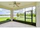 Screened lanai with tile flooring and a ceiling fan, offering peaceful views of the backyard and lake at 11619 Cambium Crown Dr, Riverview, FL 33569