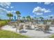 Poolside patio area with shaded seating, tables, and palm trees under a sunny sky at 11619 Cambium Crown Dr, Riverview, FL 33569