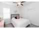 Cozy bedroom featuring a comfortable bed, ceiling fan, and white plantation shutters for natural light at 11717 74Th E Cir, Palmetto, FL 34221