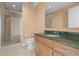 Bathroom with granite countertop, wood cabinets, and a walk-in shower with glass door at 1209 E Cumberland Ave # 604, Tampa, FL 33602