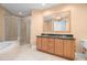 Bathroom featuring a double vanity, soaking tub, and a glass-enclosed shower at 1209 E Cumberland Ave # 604, Tampa, FL 33602