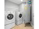 Functional laundry room features a washer, dryer, shelving and water heater at 1209 E Cumberland Ave # 604, Tampa, FL 33602
