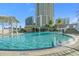 Scenic pool featuring cascading waterfalls, lush greenery, and towering building in the background at 1209 E Cumberland Ave # 604, Tampa, FL 33602