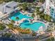 Aerial view of a luxurious double swimming pool with a bridge, surrounded by palm trees and lounge chairs at 1209 E Cumberland Ave # 604, Tampa, FL 33602