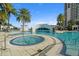 Resort-style pool area with bridge, hot tub, clear blue water, and palm trees under a sunny sky at 1209 E Cumberland Ave # 604, Tampa, FL 33602