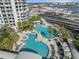 Elevated view showcasing a lagoon style pool, palm trees and deck chairs at this apartment building at 1209 E Cumberland Ave # 604, Tampa, FL 33602