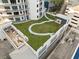 An aerial shot showing a rooftop terrace, offering a lush green space with walking paths and seating areas at 1209 E Cumberland Ave # 604, Tampa, FL 33602