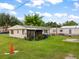 Home's private backyard offering a serene retreat with green lawn, screened-in porch, and space for outdoor relaxation and entertaining at 12324 Pittsfield Ave, Tampa, FL 33624