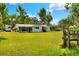 Back exterior showing a spacious yard, screened porch, and fenced area at 12631 Hobson Simmons Rd, Lithia, FL 33547