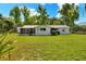 Back exterior view of house featuring screened porch and expansive grassy yard at 12631 Hobson Simmons Rd, Lithia, FL 33547