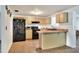 Functional kitchen featuring a black refrigerator, black appliances, and a breakfast bar, providing ample counter space at 12631 Hobson Simmons Rd, Lithia, FL 33547