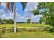 Picturesque view of an open field with scattered trees, fencing, and a clear blue sky at 12631 Hobson Simmons Rd, Lithia, FL 33547