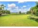 Expansive property view showcasing a green meadow, distant barns, and surrounding trees at 12631 Hobson Simmons Rd, Lithia, FL 33547