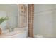 Bright bathroom with a single sink vanity, decorative art, and a shower-tub combination with a patterned curtain at 13548 Tropical Breeze Way, Hudson, FL 34669